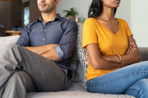 A couple sits on a sofa facing away from one another with their arms crossed. Learn how therapists in Savannah, GA can help your relationship. Search for “couples therapy savannah, ga” or “couples counseling savannah, ga” today.
