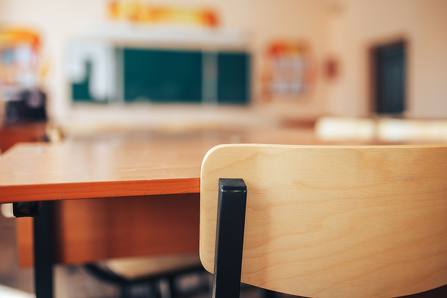 A close up of an empty school desk in an empty classroom. Learn how therapists in Savannah, GA can offer support in the summer and year-long via counseling for teenagers and other services. Search “counseling savannah, ga” to learn more.