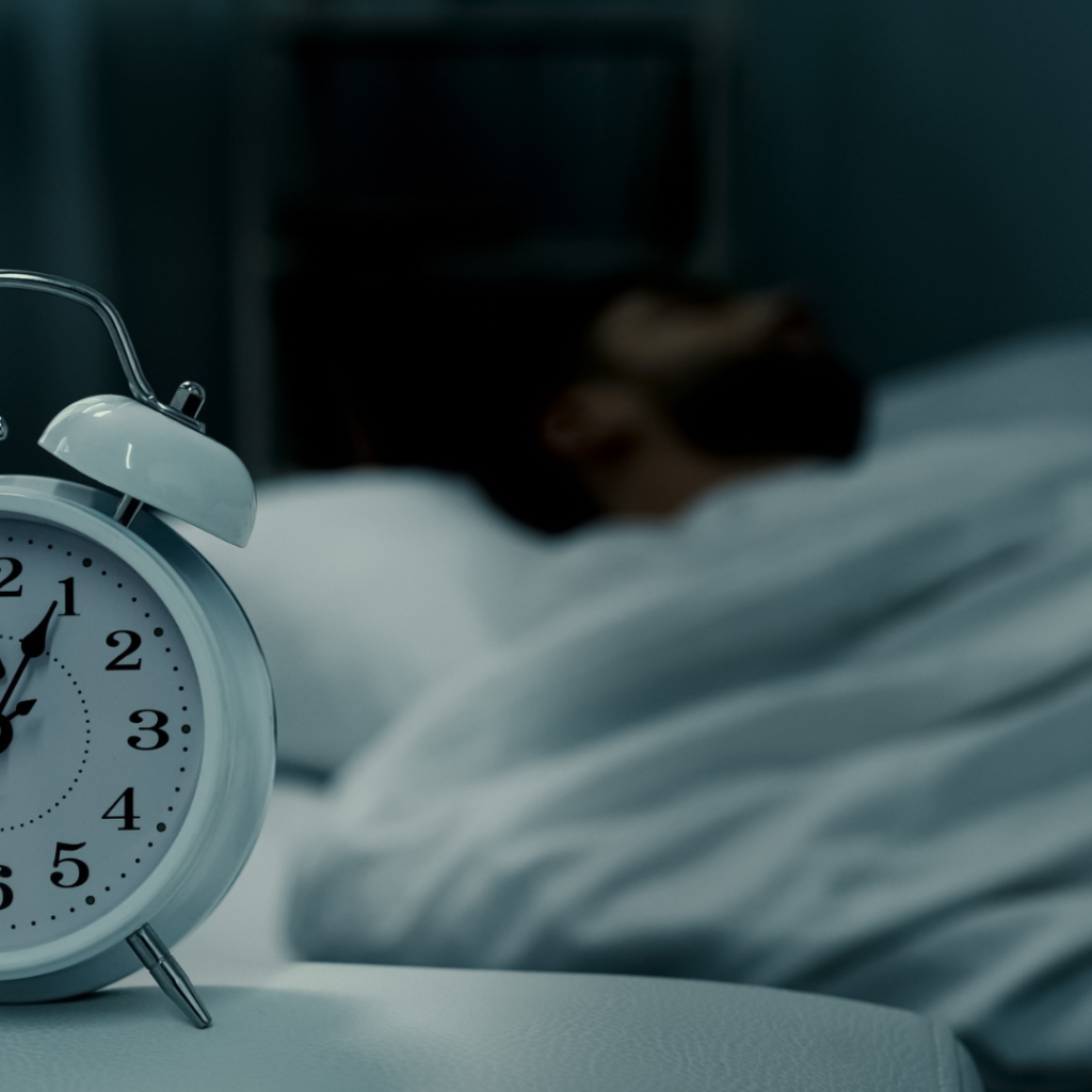 This is a picture of an alarm clock and man sleeping. This could represent a restless nights sleep that a therapist in Savannah,GA could help with