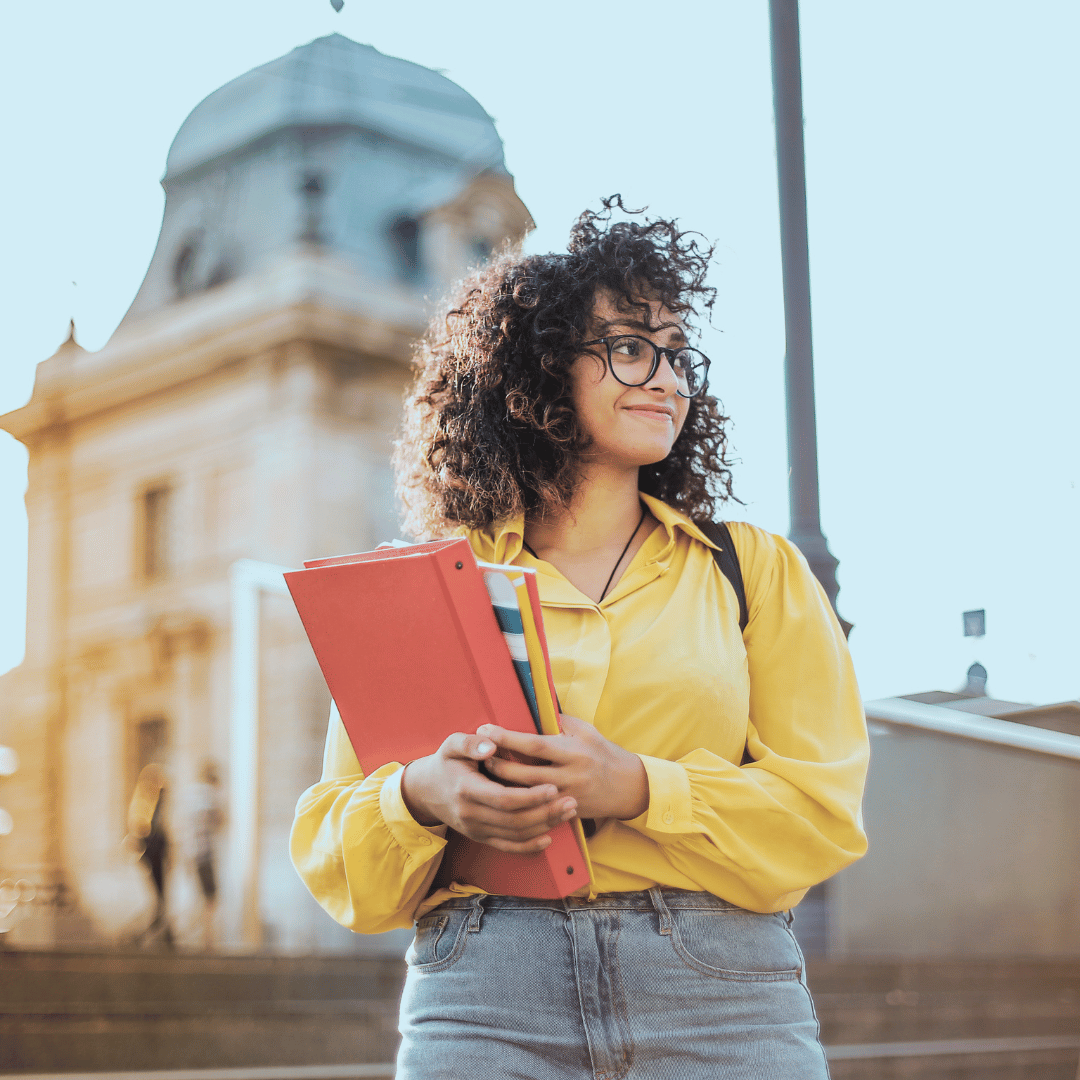 This image of a girl holding a book could represent a college student dealing with imposter syndrome in Savannah, GA 31401